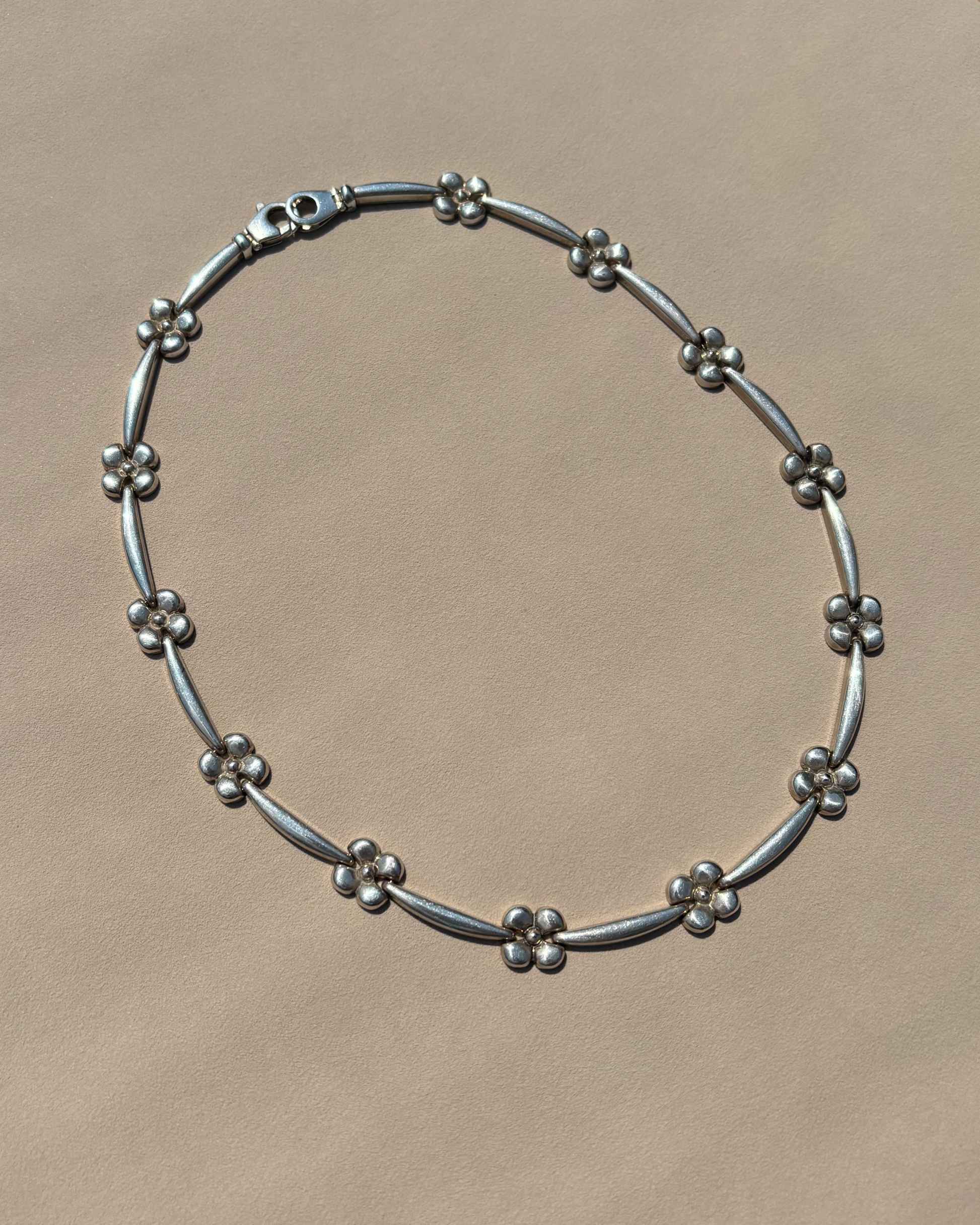 Silver beaded bracelet on a beige surface